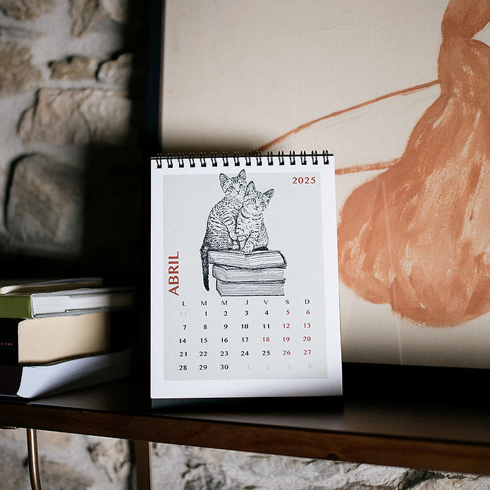 Calendario de mesa de gatos 2025 en el mes de abril de la ilustradora Laura Agustí sobre escritorio