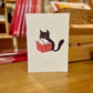 cuaderno grapado con un gato blanco y negro leyendo un libro titulado "cómo echar a la humana que está todo el día en mi casa"