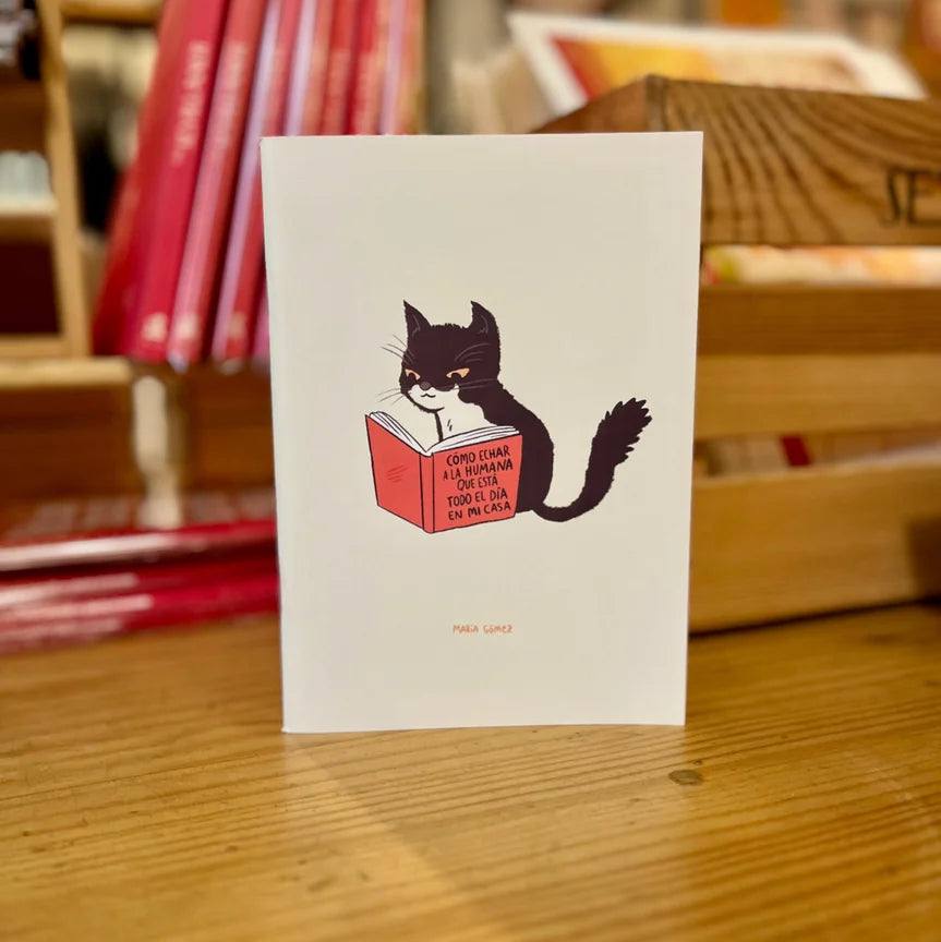 cuaderno grapado con un gato blanco y negro leyendo un libro titulado "cómo echar a la humana que está todo el día en mi casa"
