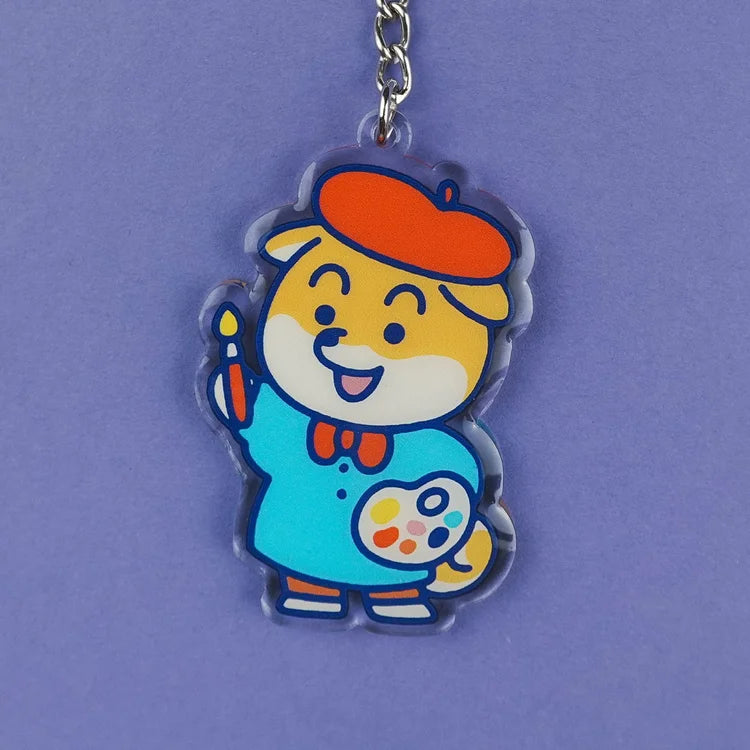 Llavero de acrílico reciclado con forma de perro shiba con boina de artista, pincel y paleta de acuarelas