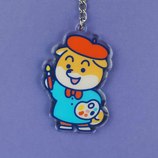 Llavero de acrílico reciclado con forma de perro shiba con boina de artista, pincel y paleta de acuarelas