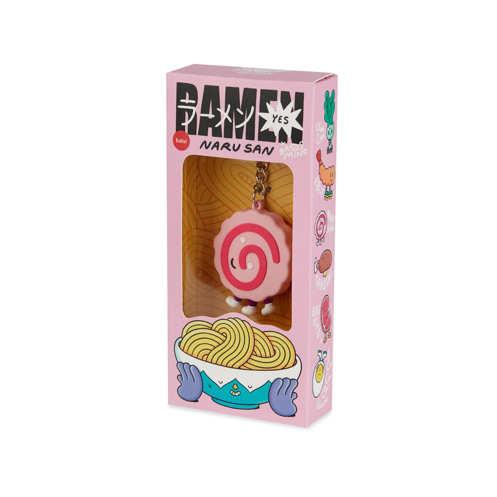 Caja rosa con detalles de dibujos de diferentes ingredientes del ramen con letras japonesas, en el interior vemos la parte frontal de un naruto, un circulo rosa con una espiral fucsia dentro, y carita sonriente, de tres patas sobre fondo blanco