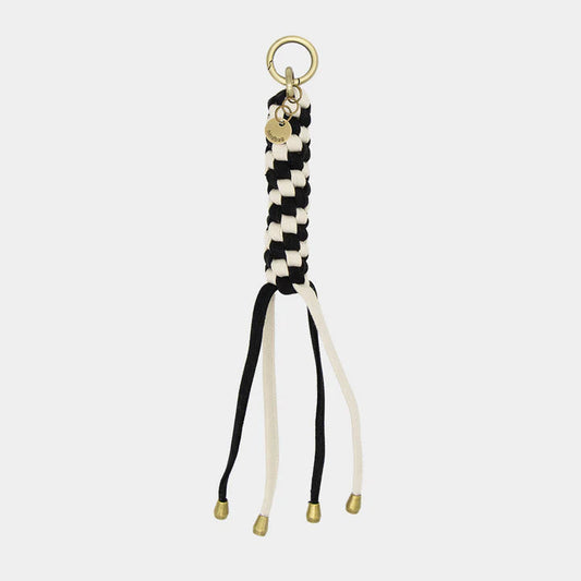 Llavero para bolso trenzado blanco y negro con mosquete de color dorado. 