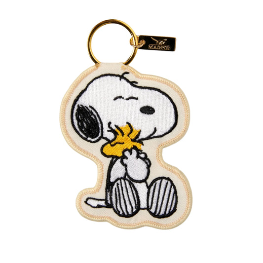 Llavero de tela bordado con forma del perro Snoopy abrazando al pájaro Emilio