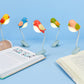 Luces de lectura de colores en forma de pájaro con un clip enganchado a libros. 