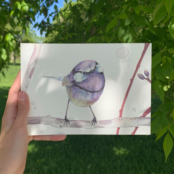 Mini print con ilustración de un pájaro morado de Marialu Gili fotografiada en un jardín