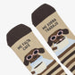 Detalle de los calcetines de UO con un perro con gafas rosas y una taza, y el mensaje «Me falta café, me sobra trabajo».
