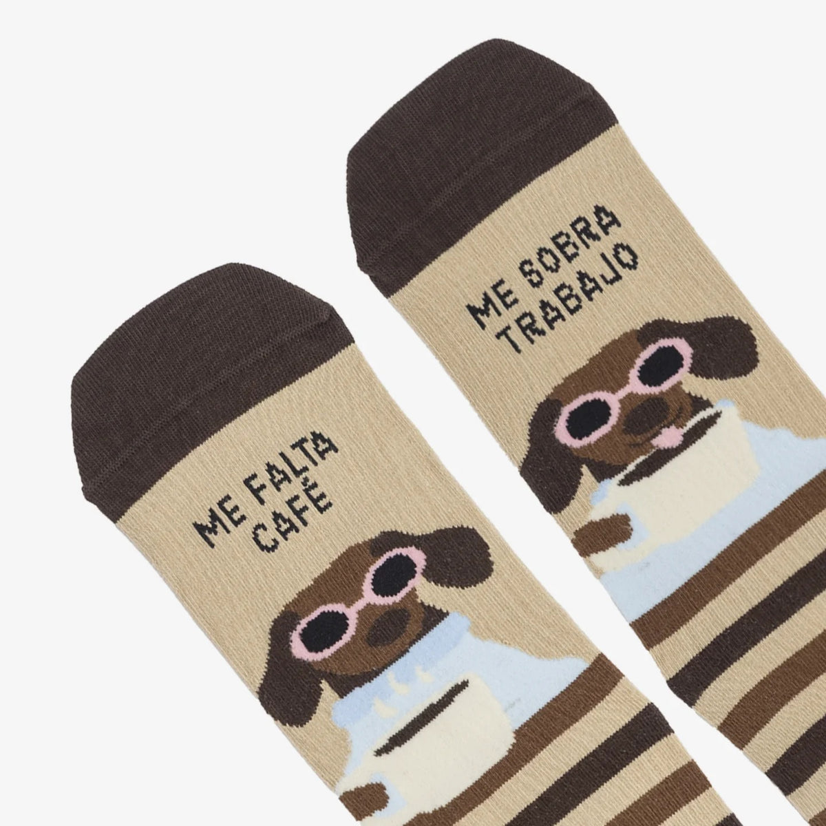Detalle de los calcetines de UO con un perro con gafas rosas y una taza, y el mensaje «Me falta café, me sobra trabajo».