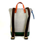 Parte de atrás con correas negras de algodón de la mochila pequeña sostenible de Daniel Chong en color gris con bolsillo delantero de cuero naranja