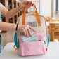 Mujer en la biblioteca metiendo una cartera en la mochila crema y pastel pequeña con bolsillos y la frase "Born to be cute" bordada