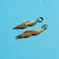 pendientes de metacrilato con aro dorado de la artista mitumi con dos mujeres nadando desnudas en color marrón con el pelo rubio y sobre fondo azul