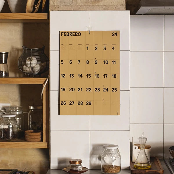 Calendario de pared 2024 tamaño A3 en papel marrón de Colla Paper colgado con cuelga fácil en los azulejos de una cocina