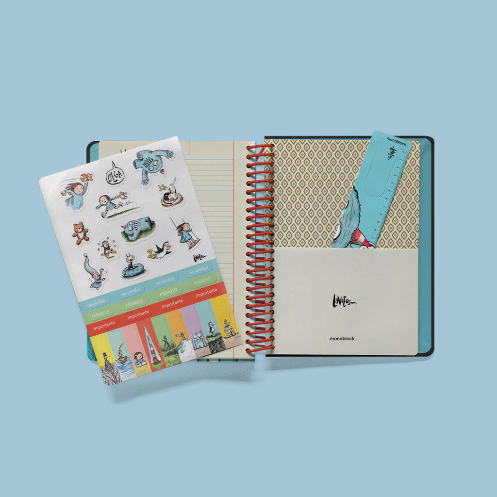 Interior abierto de agenda semanal 2027 Macanudo de Liniers con hoja de pegatinas de personajes, marcapáginas con regla y sobre portapapeles