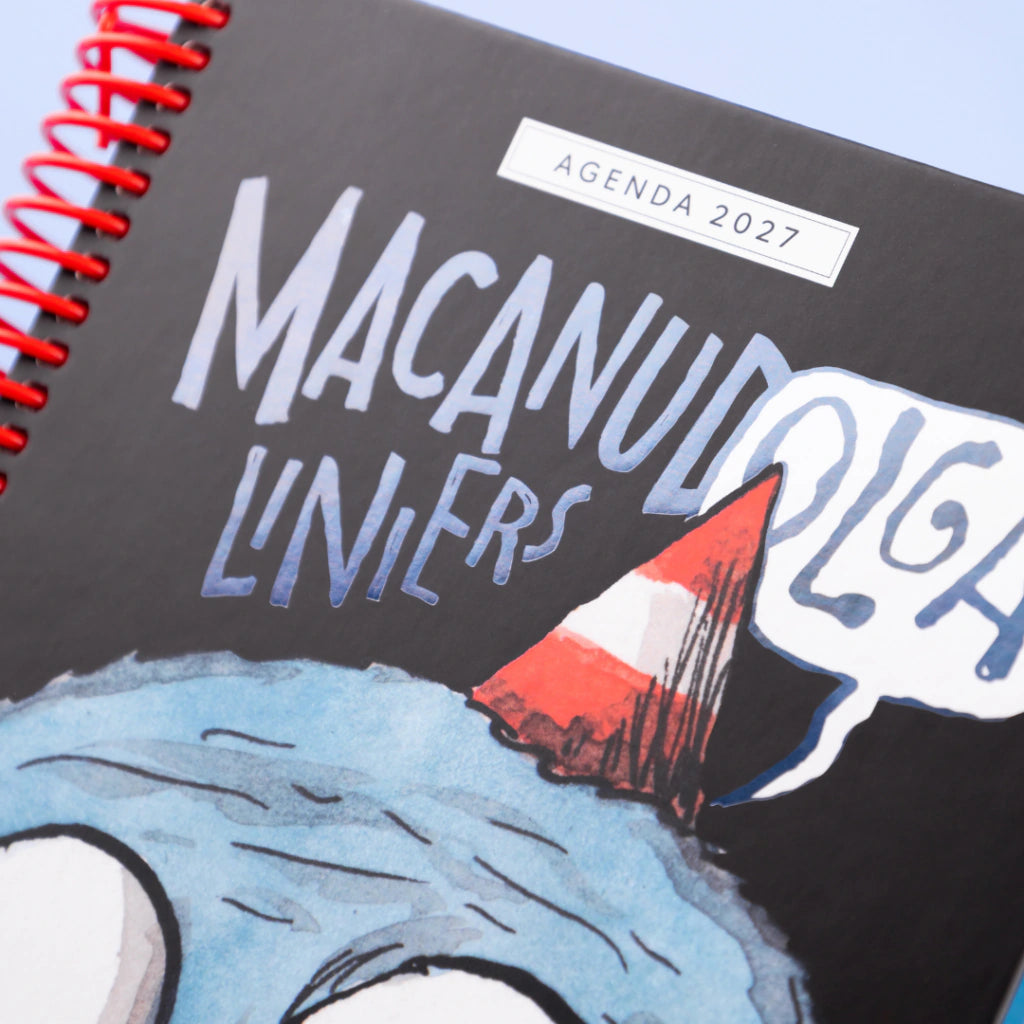 Detalle de portada negra de agenda 2027 Macanudo de Liniers con tipografía manuscrita y personaje Olga con gorro de fiesta