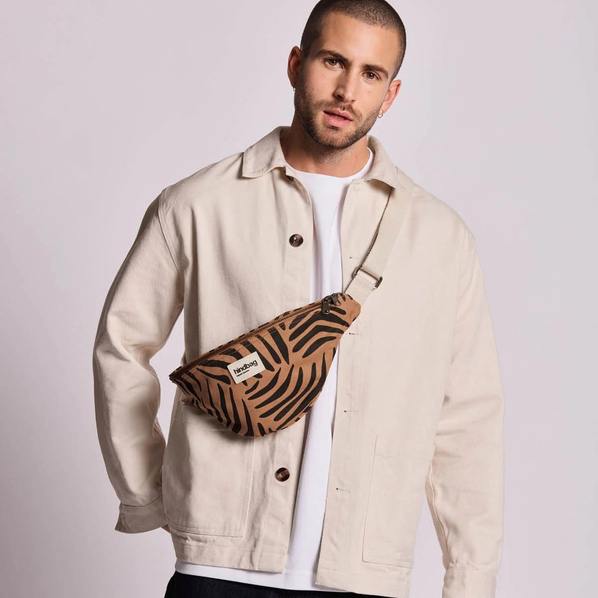 Chico con la riñonera Olivia de Hindbag en color marrón canela y estampado de cebra