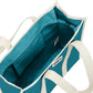 Vista del interior del bolso grande y cuadrado estilo tote bag de color azul turquesa con asas beige para llevar al hombro de la marca Hindbag