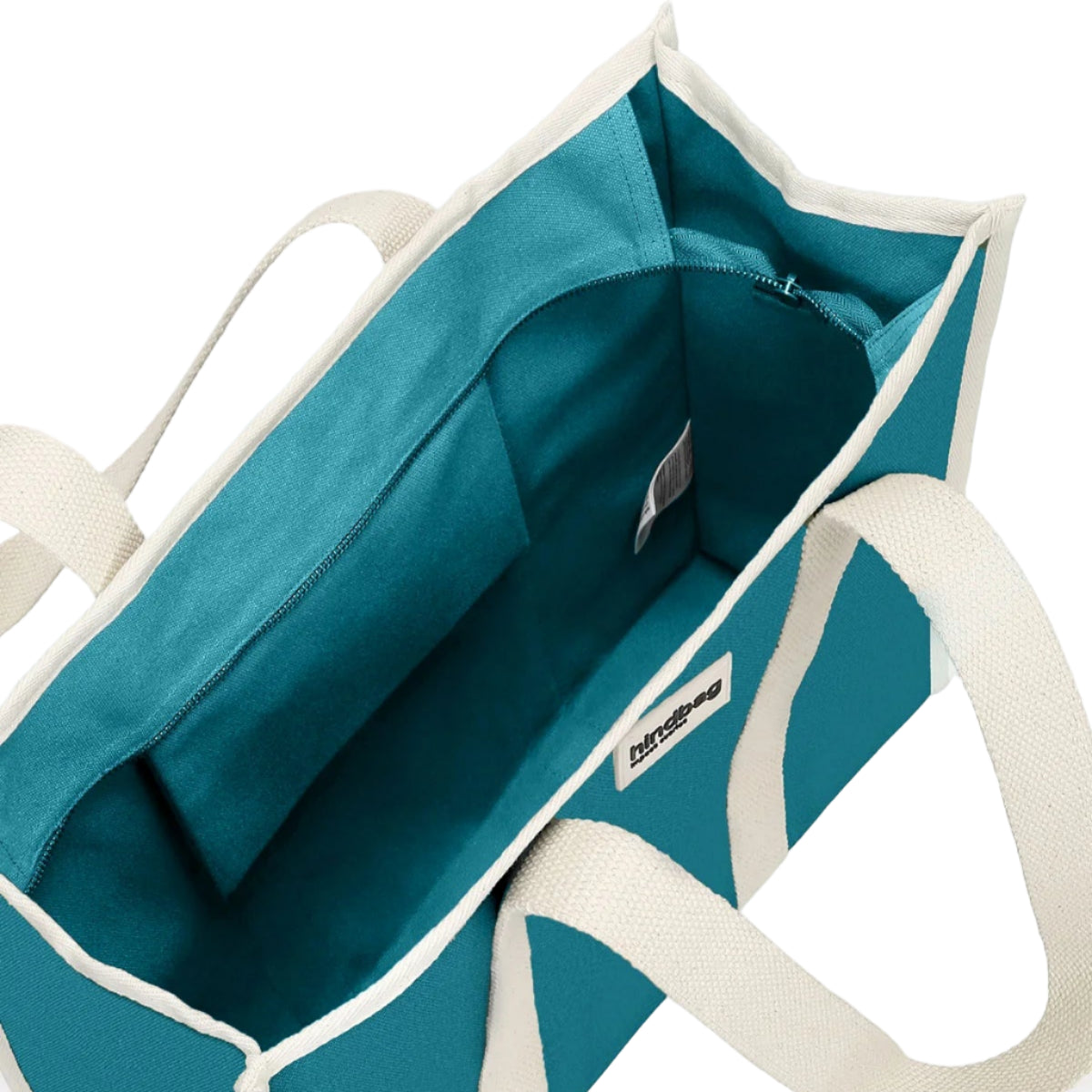 Vista del interior del bolso grande y cuadrado estilo tote bag de color azul turquesa con asas beige para llevar al hombro de la marca Hindbag