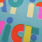 Detalle de la print en risografía de Laura Ortiz con la frase "If it's nice play it twice" sobre fondo azul