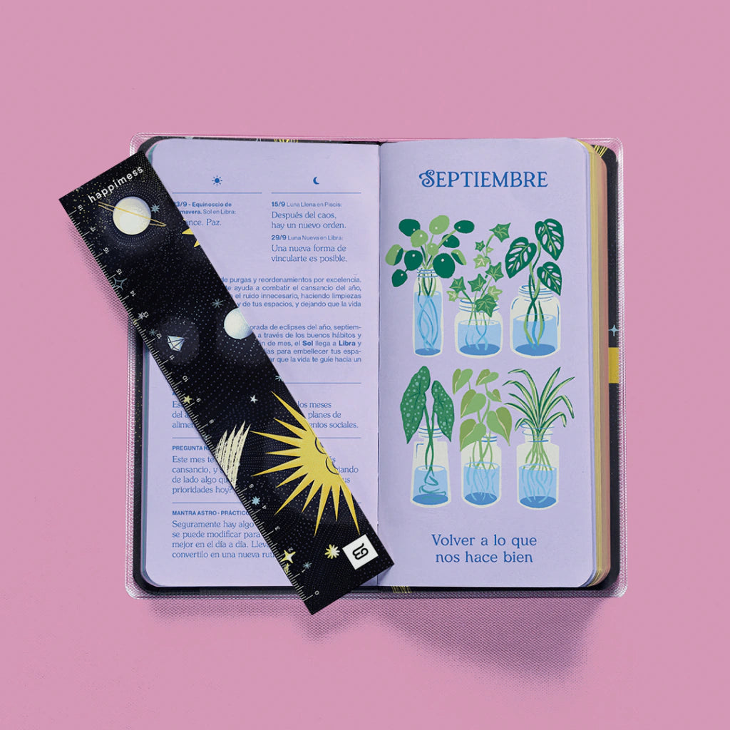 Interior la agenda pocket Astro 2027 de Happimess con portada negra, con margapáginas con motivos astronómicos y páginas con ilustraciones de plantas.