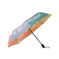 Paraguas plegable con esqueleto negro y estampado degradado de colores con el mensaje Hello rain, welcome back en letras mayúsculas blancas