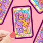 pegatina imitando la carta de Tarot Los Amantes, con dibujo colorido de dos gatos abrazados