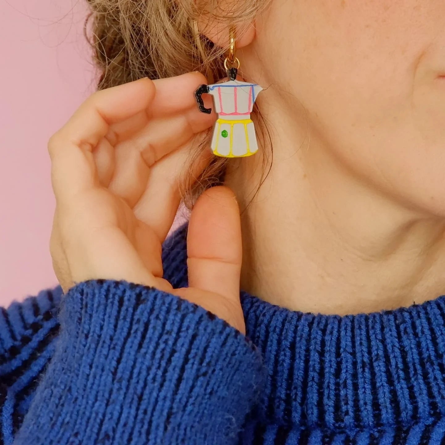 Mujer con jersey azul y los pendientes de metacrilato con forma de cafetera italiana de la marca valenciana mitumi