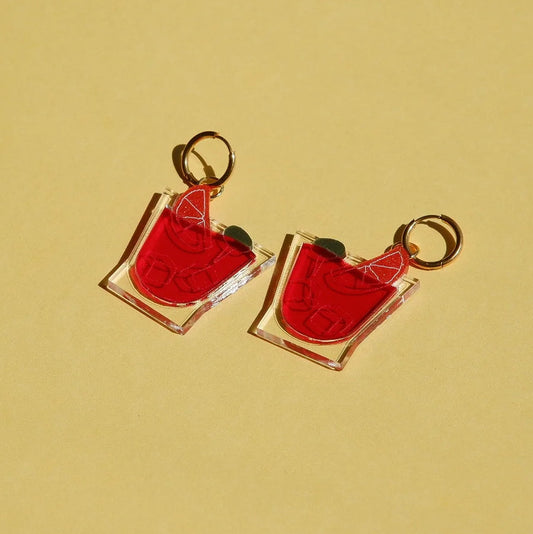 Pendientes con forma de vasito de vermú con una odaja de naranja