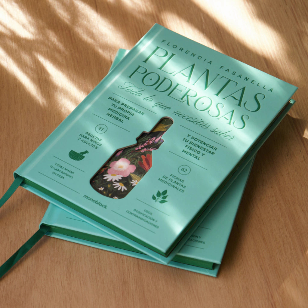 Libros Plantas Poderosas de Florencia Fasanella con todo lo que necesitas saber sobre fitoterapia sobre una mesa de madera.
