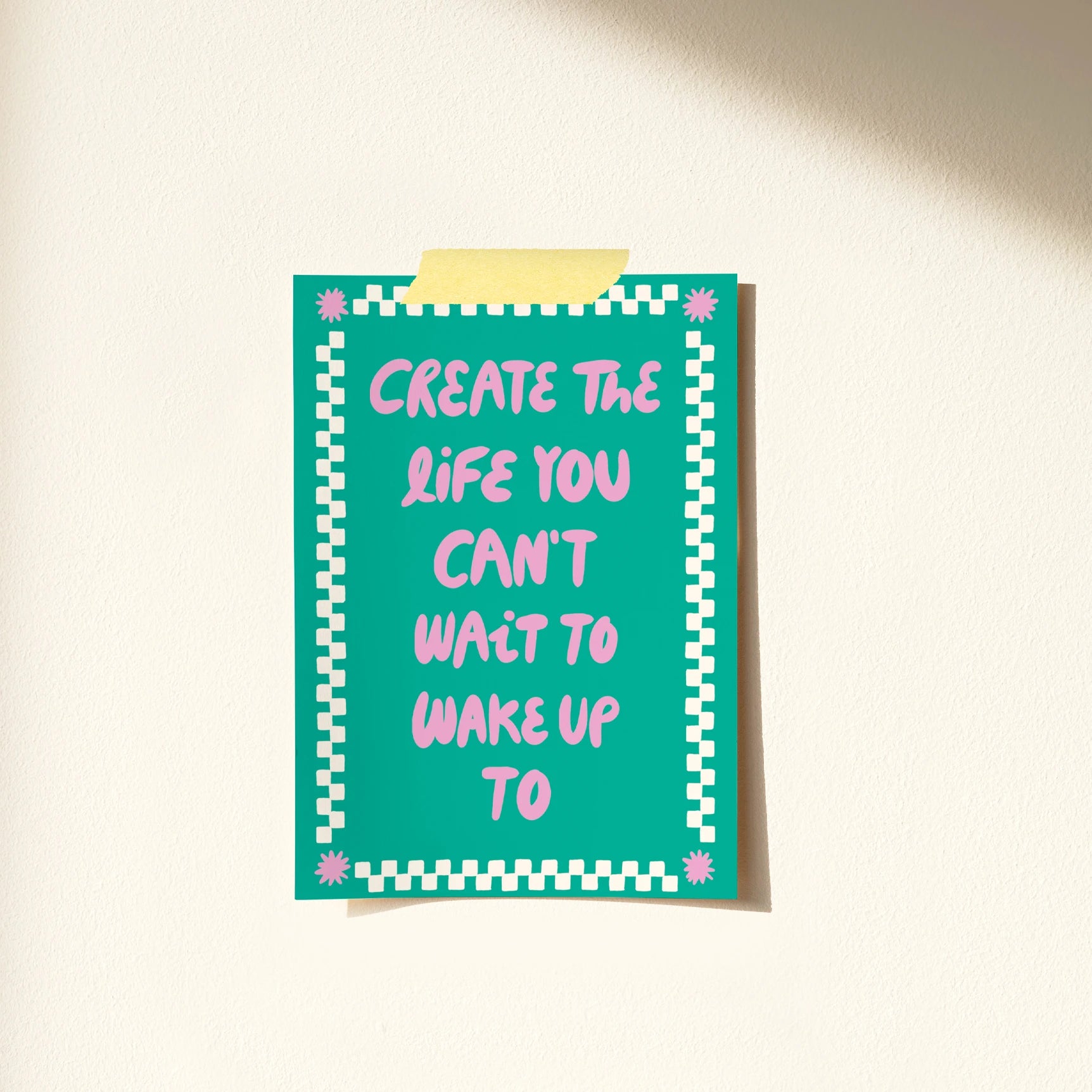 Postal de Laura Ortiz en color verde con el texto "Create a life you can't wait wait to wake up to" en rosa