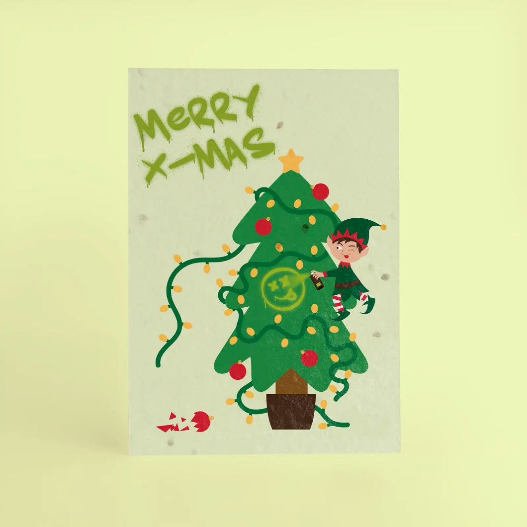 Tarjeta de Navidad plantable de Resetea, con ilustración de un elfo con cara de pillo subido a un árbol de navidad haciendo un graffiti. en la esquina superior MERRY X-MAS con estilo urbano