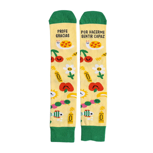 Calcetines estampados con dibujos de flores, manzanas, lápices, cerezas y caracoles con el mensaje Profe gracias por hacerme sentir capaz