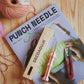 Libro Punch Needle para aprender esta técnica de bordado con material de bordado en una mesa de madera
