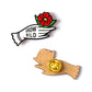 Pin de madera con forma de mano con guante blanco sosteniendo una flor roja con el mensaje Grow wild