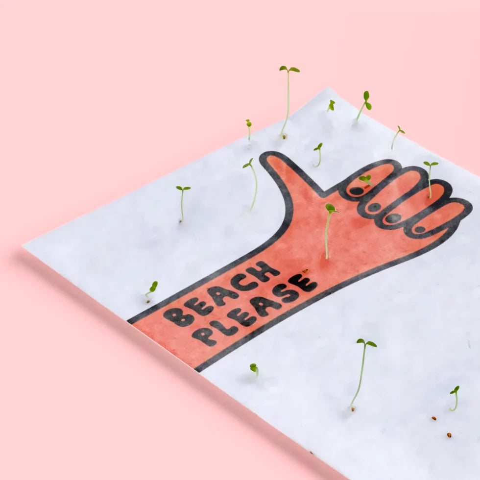 detalle de lapostal con semillas dentro de la marca resetea con un puño cerrado levantando el pulgar con el texto Beach please, con brotes saliendo de ella