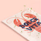 detalle de la postal con semillas dentro de la marca resetea con una langosta dibujada en color rojo con el texto Dolce Vita en color azul con brotes saliendo de ella