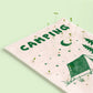 detalle de la postal con semillas dentro de la marca resetea con un dibujo de una tienda de campaña, unos árboles y la luna y las estrellas con el texto Camping con brotes creciendo de ella