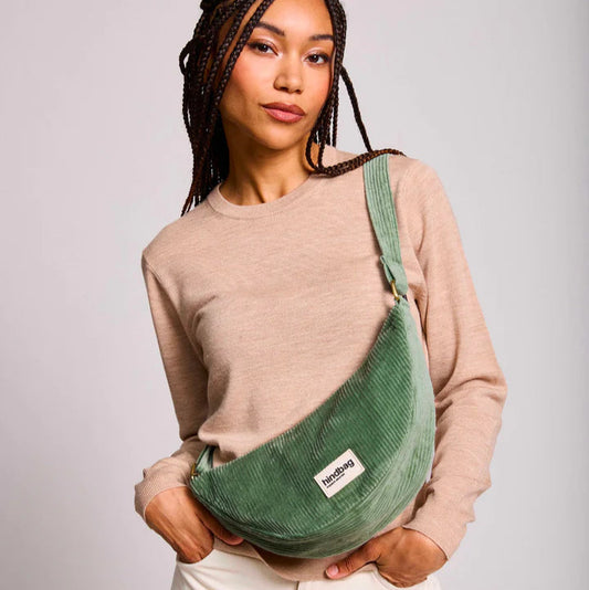 Mujer con bolso riñonera en forma de media luna con tejido de pana verde agua