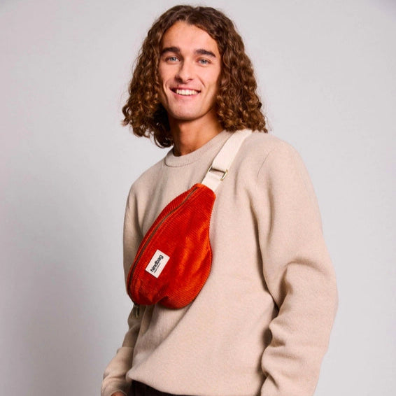 Hombre con riñonera de pana modelo Olivia de Hindbag color rojo ladrillo