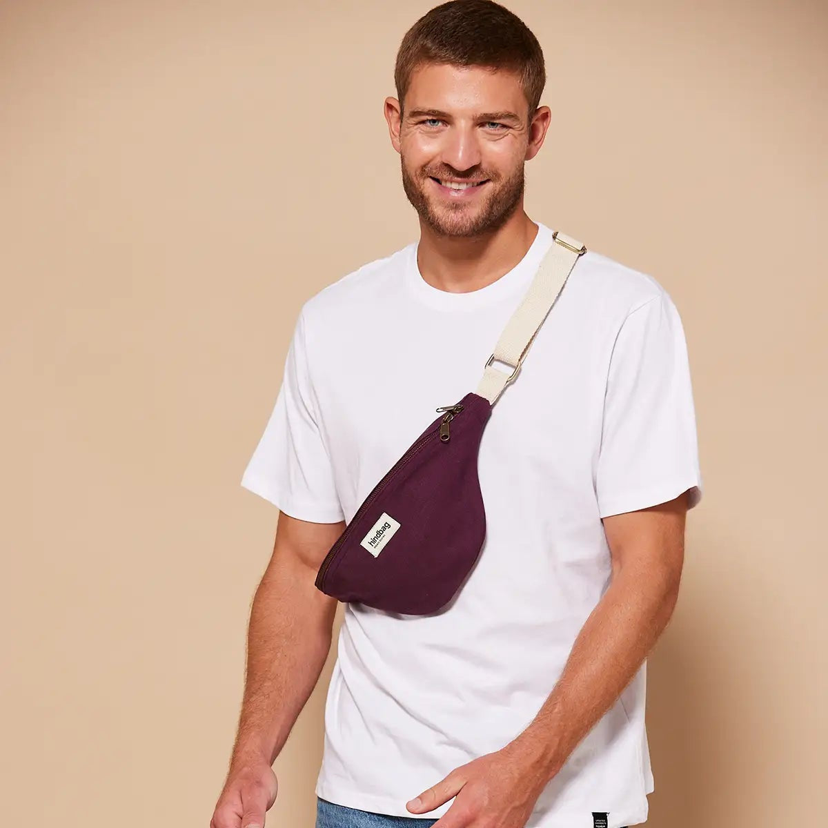 Hombre con camiseta blanca y la riñonera color ciruela de la marca francesa Hindbag