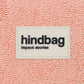 Detalle del tejido y la etiqueta frontal de la riñonera de rizo rosa de la marca francesa Hindbag