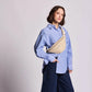 Mujer con camisa a rayas y riñonera Olivia en tejido tranzado en colores crudo de la marca francesa Hindbag
