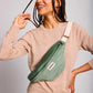 Mujer con una riñonera de pana modelo Olivia de Hindbag color verde agua