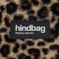 Detalle de la etiqueta de la riñonera con tejido de peluche y estampado animal print de leopardo de la marca francesa Hindbag