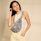 Mujer con la riñonera leopardo con fondo beige de la marca francesa Hindbag