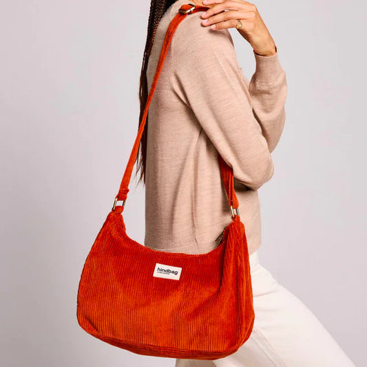 Mujer con bolso de pana de color rojo ladrillo colgado al hombro
