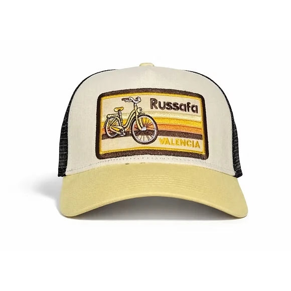 Gorra beige y amarillo crema con parche bordado del barrio de Ruzafa con una bicicleta