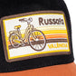 Primer plano de la gorra negra y marrón con parche bordado del barrio de ruzafa con una bicicleta