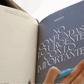 Interior de la Agenda 2027 negra Journal Sessions abierta en mayo con página de frase inspiradora No confundas lo urgente con lo importante en tipografía grande sobre fondo azul grisáceo
