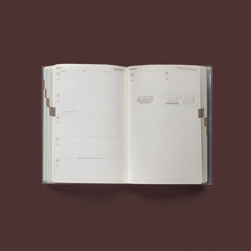 Interior de la Agenda 2027 negra Journal Sessions abierta en una semana con páginas punteadas estilo Hobonichi y pregunta de reflexión semanal