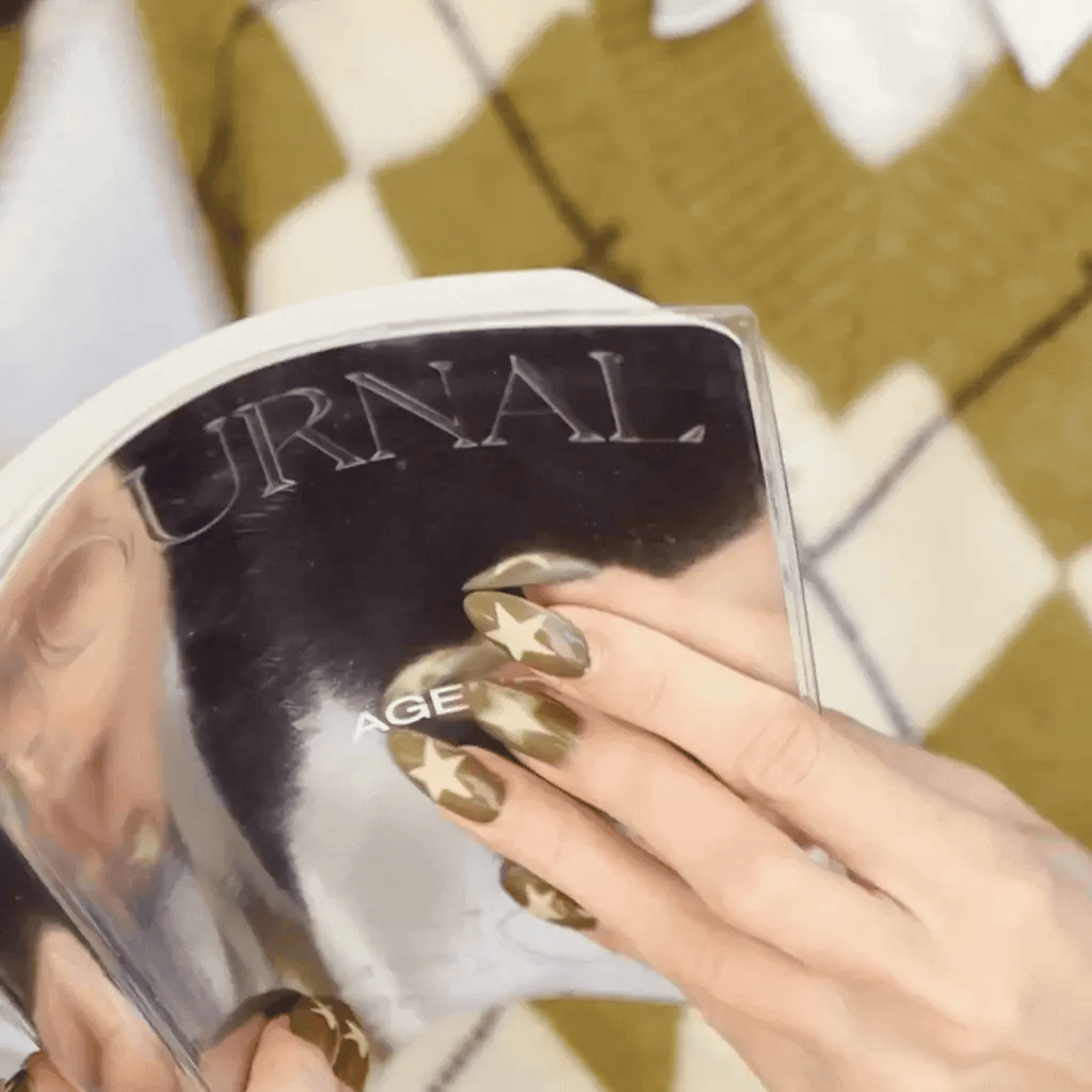 Mujer hojeando la agenda Journal Sessions con portada plateada brillante
